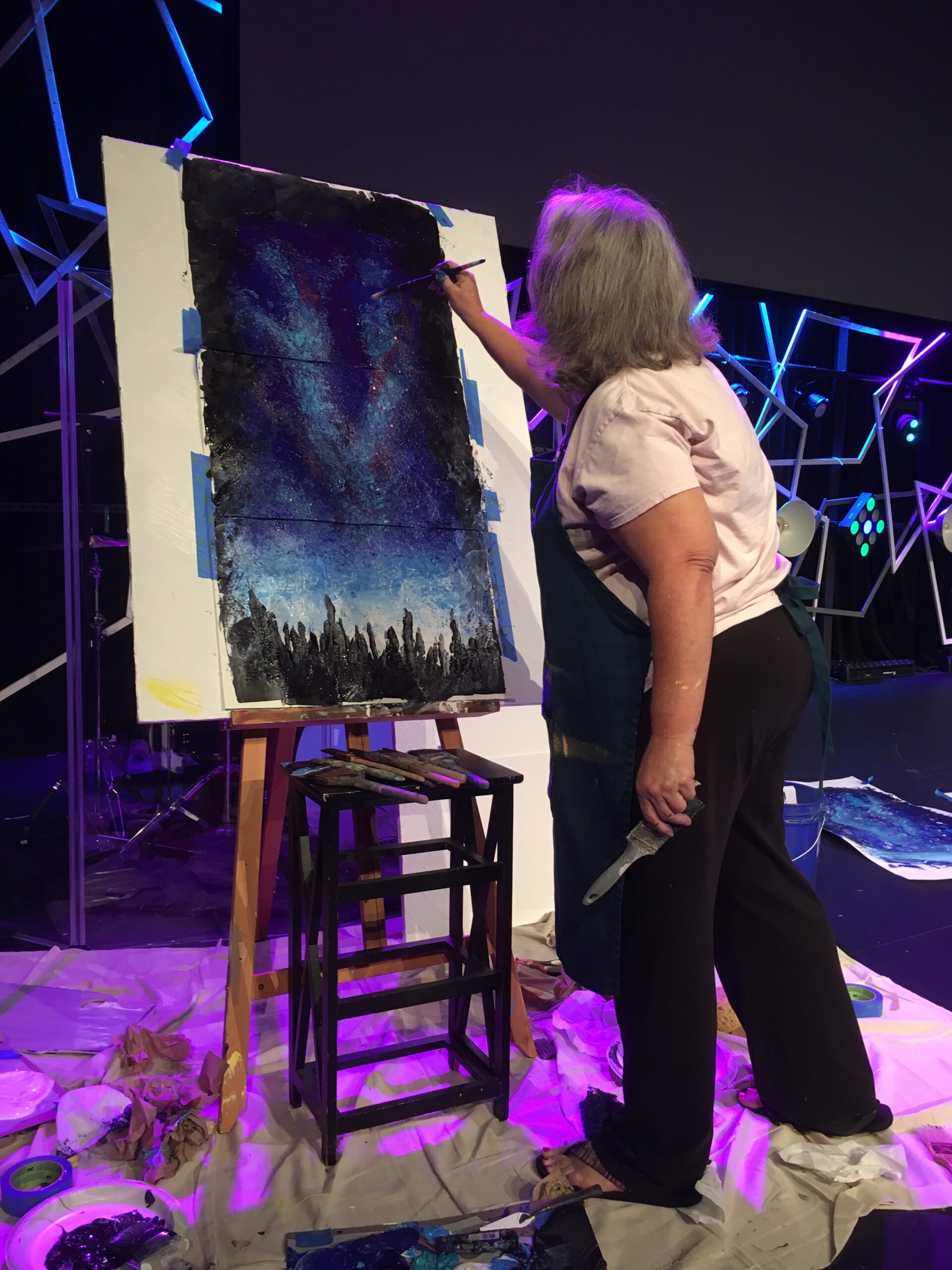 Woman in apron painting blue painitng abstract purple light